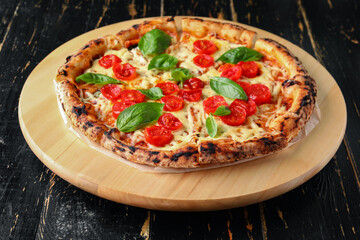Board with tasty pizza Margarita on black wooden background