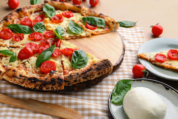 Board with tasty pizza Margarita and Mozzarella cheese on table