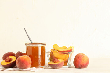 Jar with sweet peach jam and fresh fruits on table