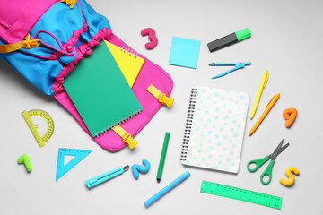 Composition with stylish school backpack and different stationery on grey background
