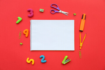 Composition with blank notebook, different stationery and numbers on red background