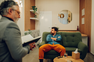 An angry client is having resistance while sitting with arms crossed in the doctor's office with a...