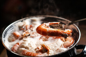 Large king prawns are boiled in a saucepan.