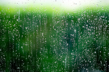 Drops of water, rain on glass on a green background.