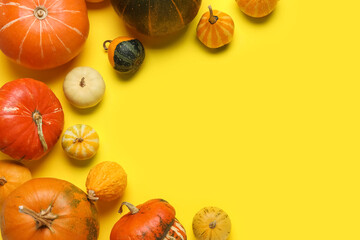 Different fresh pumpkins on yellow background