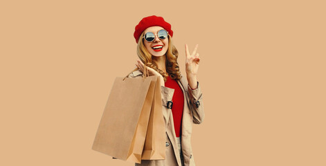 Autumn style outfit, portrait of beautiful happy smiling young woman with shopping bags wearing red...