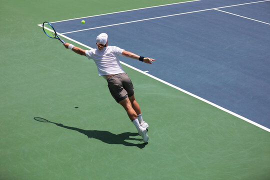 tennis player reaching for the ball, action shot