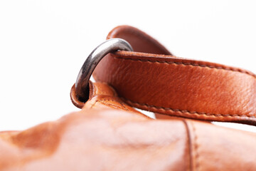metal strap ring on a brown leather bag. Close-up.