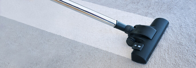 Strong vacuum cleaner making a clean streak on a gray carpet, eliminating house dust mites which...