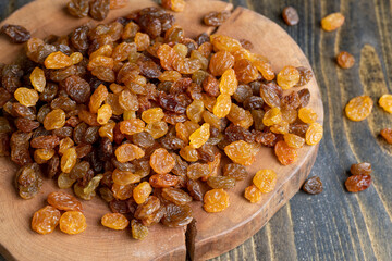 Dried yellow golden raisins on a board