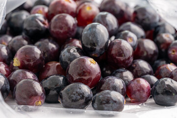 Red and black grapes in clear bag.