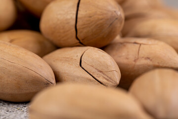 unpeeled pecans in a shell on the kitchen table, close up