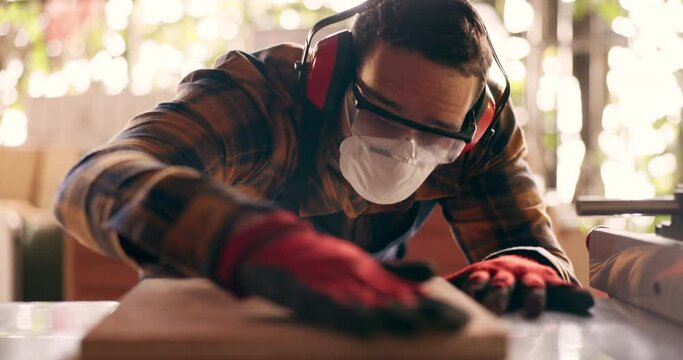 Wood, carpenter and dust with man in workshop for furniture, manufacturing and renovation. Production, tools and design with person and equipment in home garage for remodeling, board and handyman