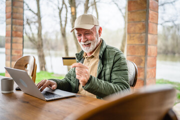 Man senior caucasian male shopping online sit with laptop computer