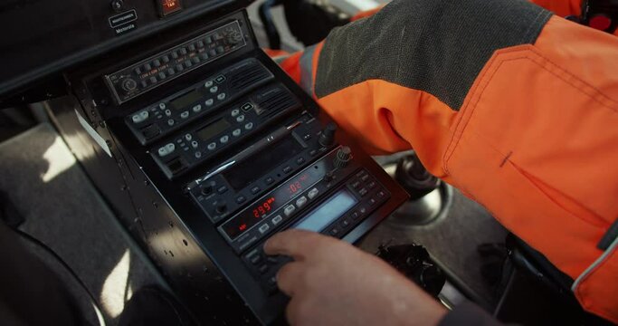 Close up of man setting radio frequency and adjusting electronic devices. Pilot performing preflight procedure in helicopter. Airport and aviation concept