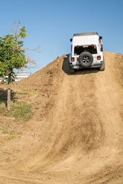 Loveland, CO, USA - August 27, 2023: Jeep Wrangler, Rubicon model, climbing on a dusty training drive off-road course.