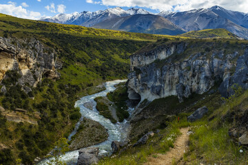 mountain valley river in the mountains with snow capped mountains in the background
