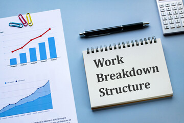 There is notebook with the word Work Breakdown Structure. It is as an eye-catching image.