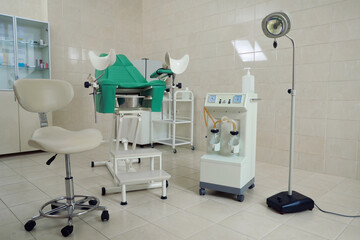 Examination room with gynecological chair and medical equipment in clinic