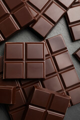 Delicious dark chocolate on black table, flat lay