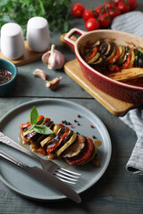 Delicious ratatouille served with basil on grey wooden table