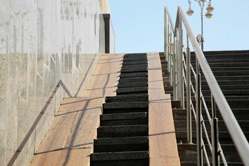 Staircase and ramp with metal handrail near building outdoors