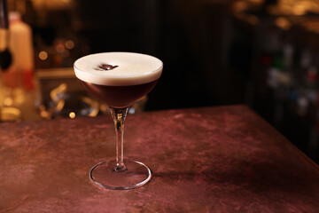 Glass of delicious Espresso Martini on bar counter, space for text. Alcoholic cocktail
