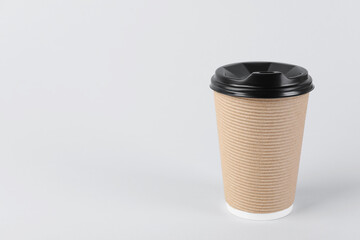 Paper cup with plastic lid on light background, space for text. Coffee to go