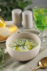 Delicious cream soup with tarragon, spices and potato in bowl on table