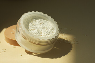 Rice loose face powder on beige background, closeup. Space for text