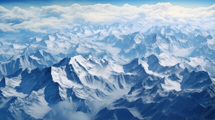 Aerial view of a mountain range showing rugged terrain and snow capped peaks.