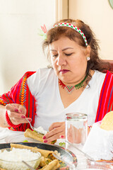 Mexican woman preparing a taco during a traditional mexican meal