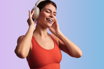 Naklejka premium Cheerful sportswoman listening to music in headphones