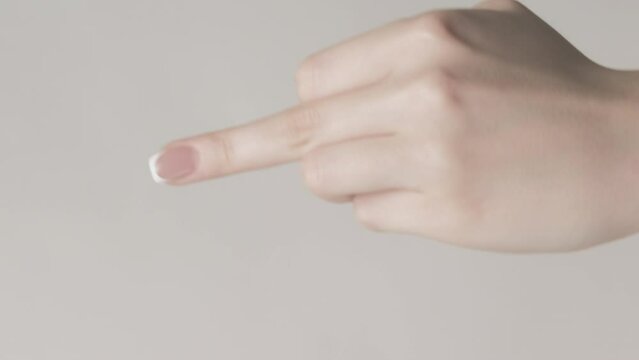 Vertical video. Middle finger. Rude gesture. Woman hand showing set of 3 impolite signs offensive behavior isolated on gray free space background.