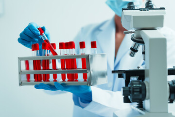 Close up dedicated hematology lab technician scrutinizing blood sample analysis under microscope,...