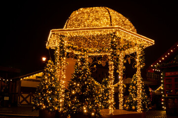 Holiday Decorated and illuminated street at night in Gdansk Poland. Beautiful Christmas fair in the old town at night. Advent winter time in Europe background. Christmas Markets in December Ornamented