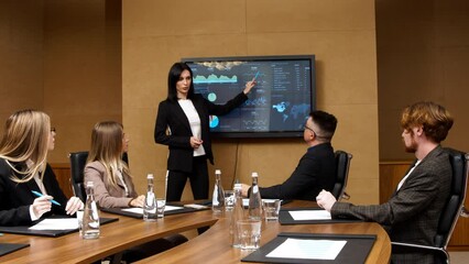A diverse multinational team of professional business people meet in the conference room of a modern office. Creative team at the table discussing data analysis and planning a marketing campaign