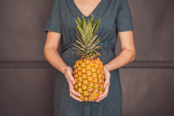 A pregnant woman's belly, beautifully showcasing the size of her baby, likened to a pineapple. Explore the potential benefits and harms of pineapple during pregnancy and childbirth