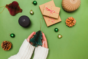 Female hands holding Christmas decor made of paper, preparing for holidays