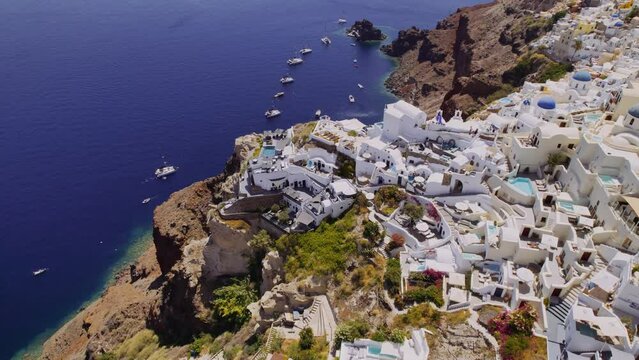 Aerial top view of Greek village with white houses. Santorini, Greece. Cinematic 4k.