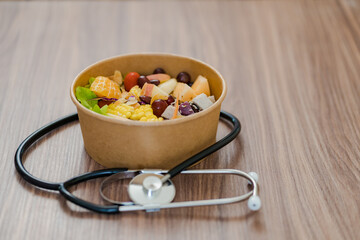 Healthy food placed on a wooden background and a heart stethoscope placed next to the concept of weight control Alternative food and a healthy life