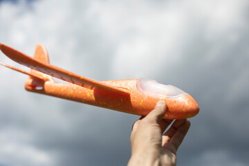 Toy plane in hand. Airplane to play. Lightweight glider.