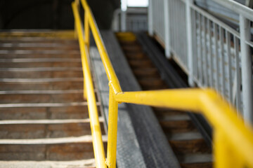 Fototapeta na wymiar Steep stairs. Yellow handrail for climbing stairs. Overhead road crossing.