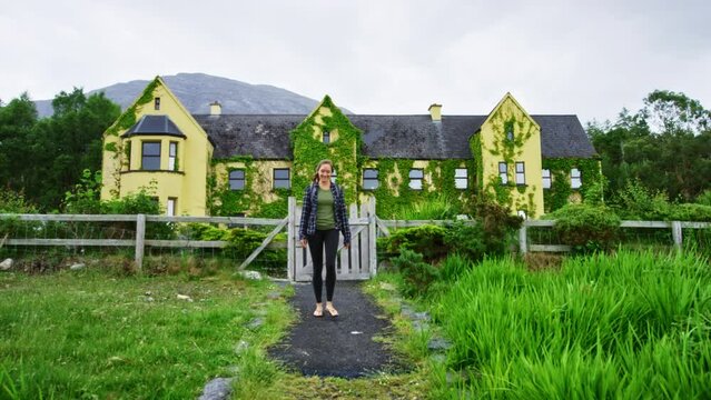 Woman Walking Away From 19th Century Built Lough Inagh Lodge