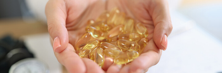 Doctor holding transparent yellow capsules in hands