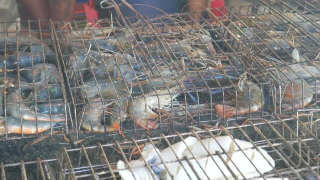 Grilled live blue river prawn in cage on hot charcoal at Pattaya fish market