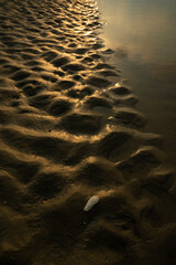 Wet sand in sea beach. Land view after water run off at sea beach. Beach view during Sunset.