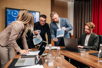 Successful entrepreneur specializing in charting during a meeting with a multinational employee. Mature businessman is discussing work at the conference table in the office.