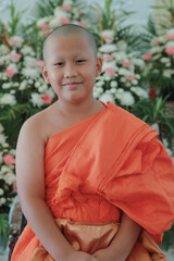 portrait of buddhist novice wearing thai monk clothes standing outdoor