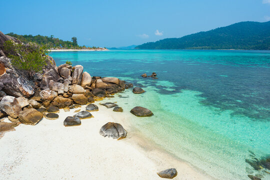 Turquoise water and white sand beach on a tropical island. Beach at tiny Kla Island with view of Ko Lipe (left) and Ko Adang (right)